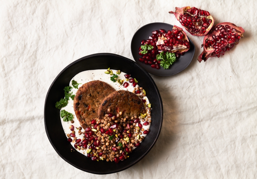 Burger di melanzane su salsa di yogurt e tahina con lenticchie melagrana e pistacchi