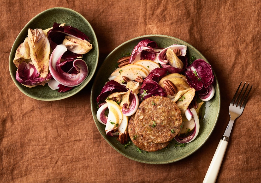 Burger ai carciofi e pomodori secchi con insalata di radicchi, pere e noci pecan