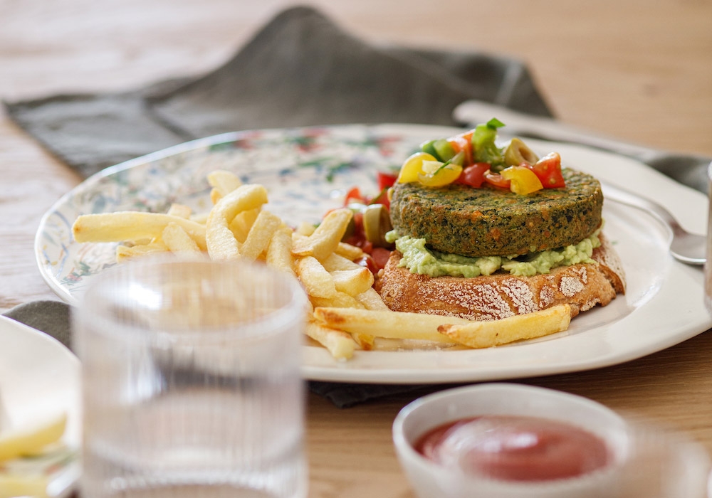 Burger su crostoni di pane con crema di avocado pomodorini e olive