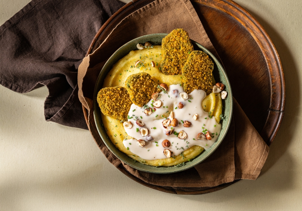 Mini cotolette con polenta morbida alle erbe, fonduta e nocciole tostate