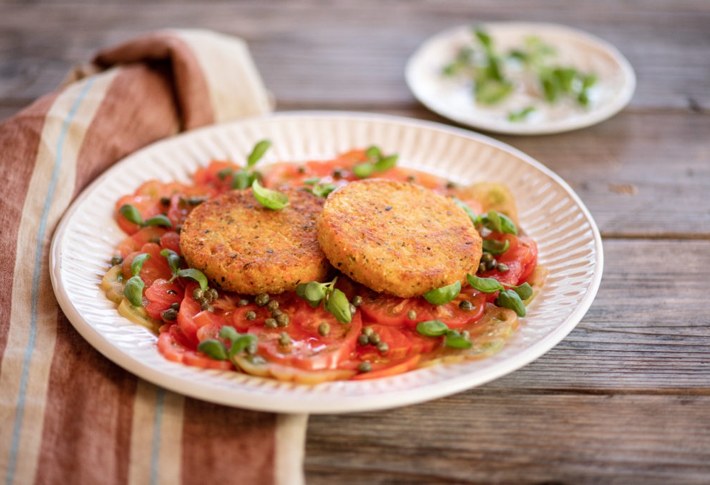 Burger ai ceci su carpaccio di pomodori ai capperi e basilico