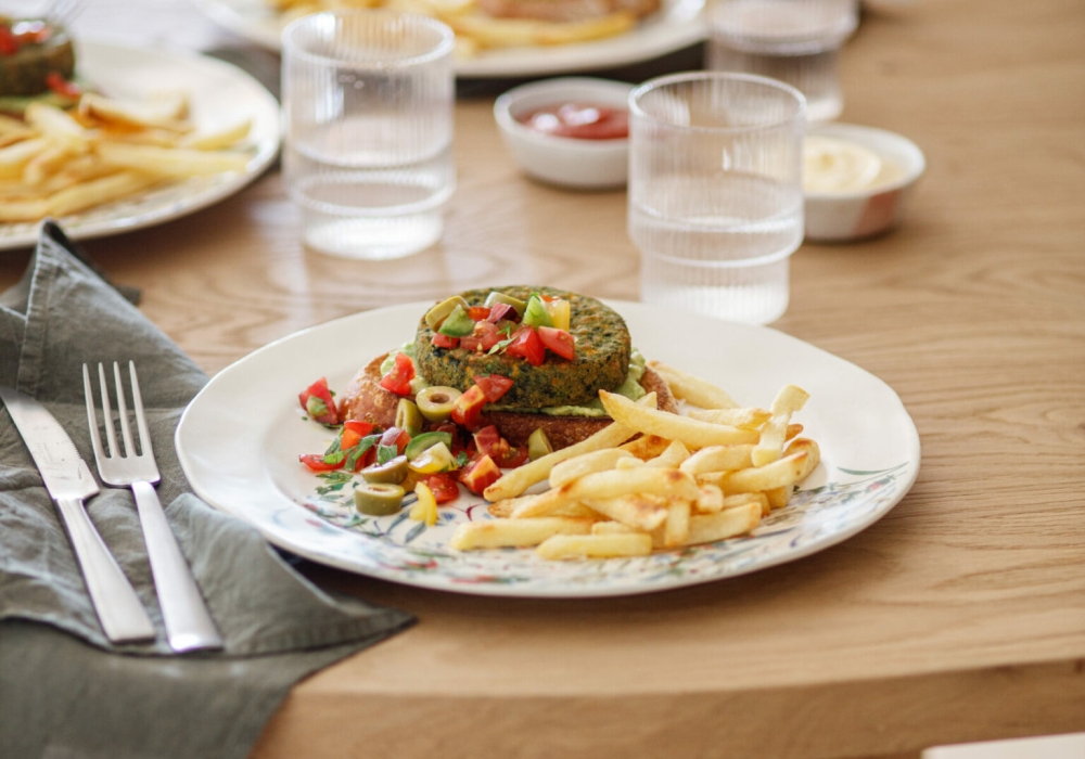 Burger agli spinaci su crostoni di pane con crema di avocado, pomodorini e olive